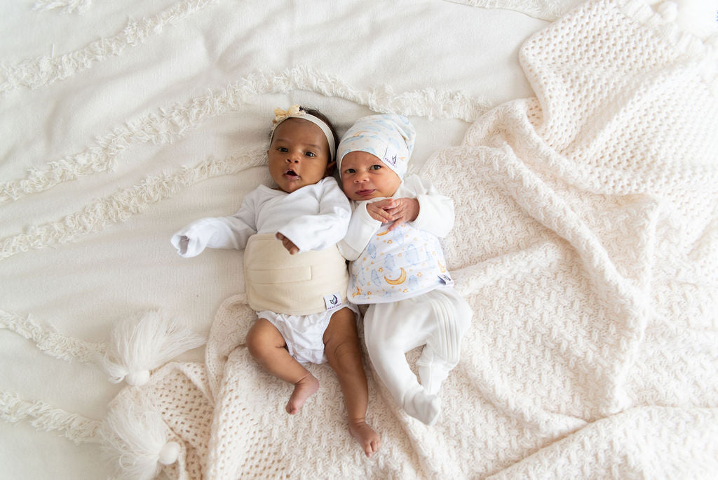 two babies on bed wearing memeeno belly bands for infant gas and colic relief