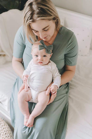 mom holding baby in white belly band for gas and colic