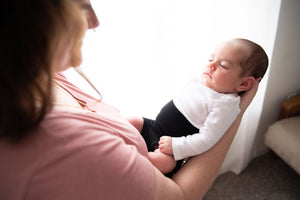 mom holding baby wearing organic cotton black memeeno baby belly bloomer