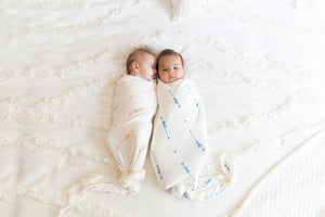 two babies wrapped  in love him and love her swaddle