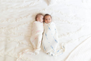 two babies wrapped in love him and love her swaddle