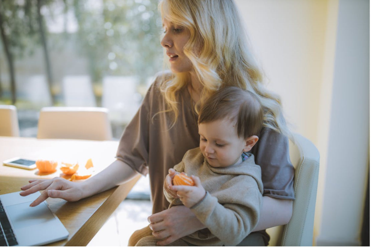 Mom holding baby while on computer