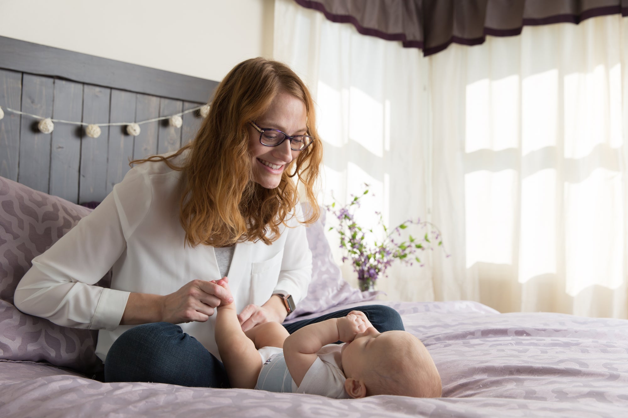 mom and baby with belly band for colic relief doing bicycle legs