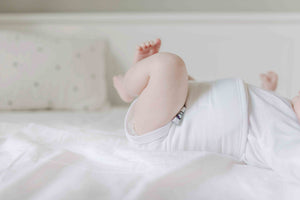 photo fo legs and torso of baby wearing white baby belly band for gas and colic