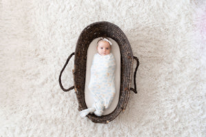 baby swaddled in memeeno luna swaddle blanket in a basket