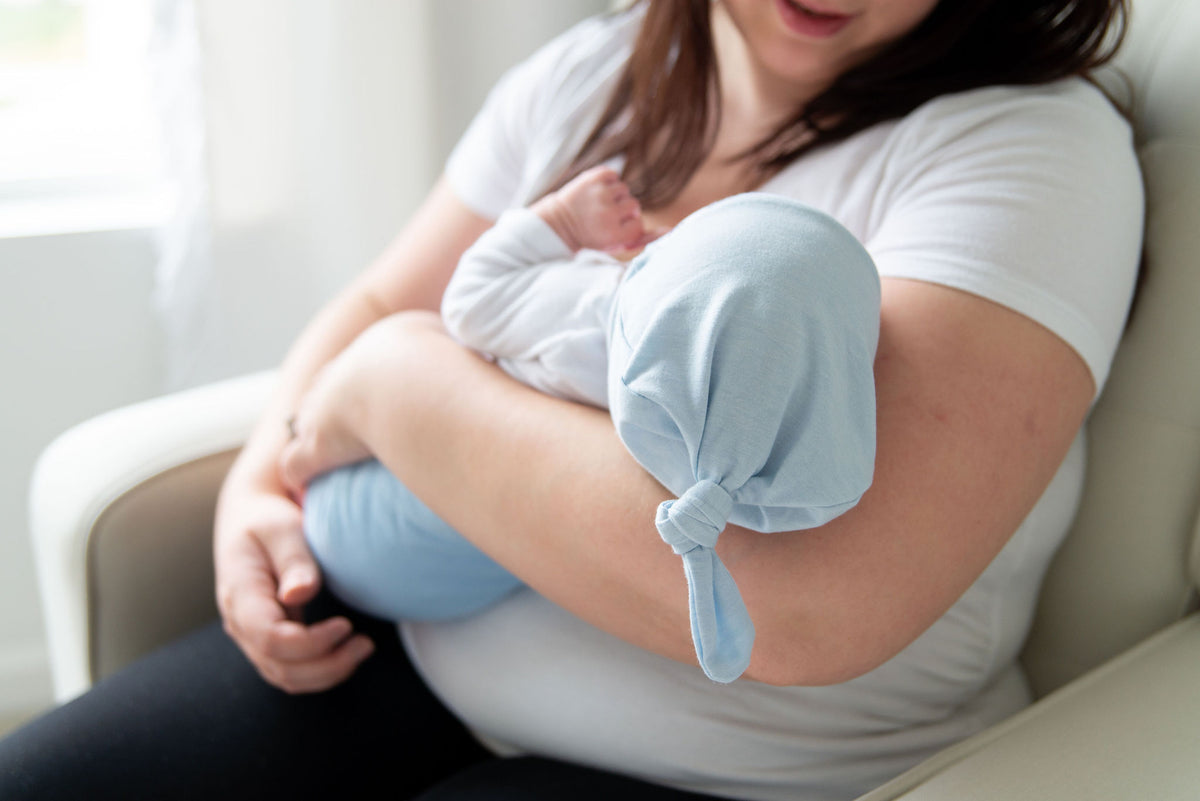 mom holding baby in blue belly band for gas and colic