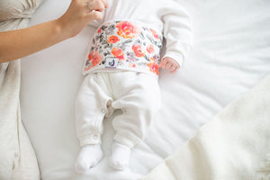 baby on bed wearing floral baby belly band organic cotton