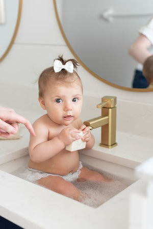baby in sink being cleaned with memeeno olive oil soap