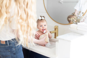 mom and baby washing in the sink