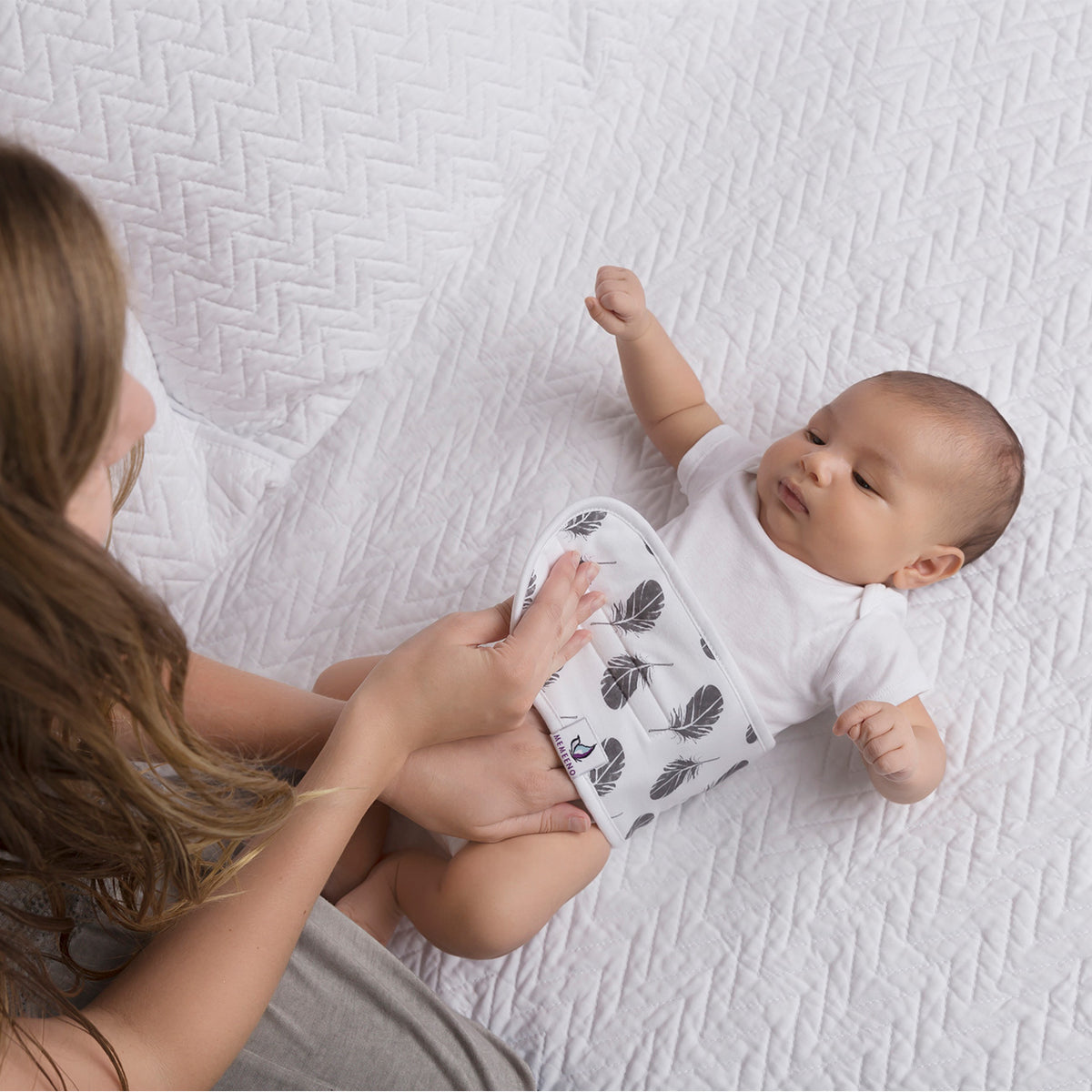 mom putting Baby Belly Band - Plume - on baby