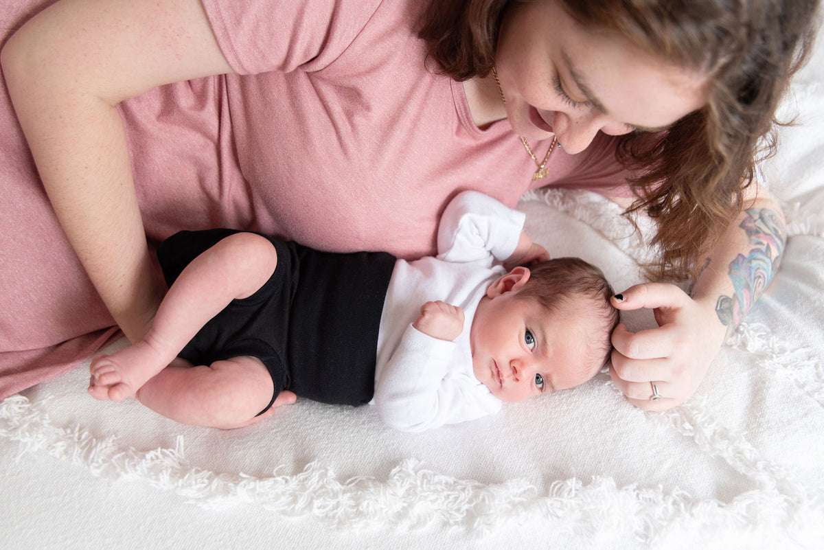 mom and baby lying on the bed in memeeno baby belly bloomer noir