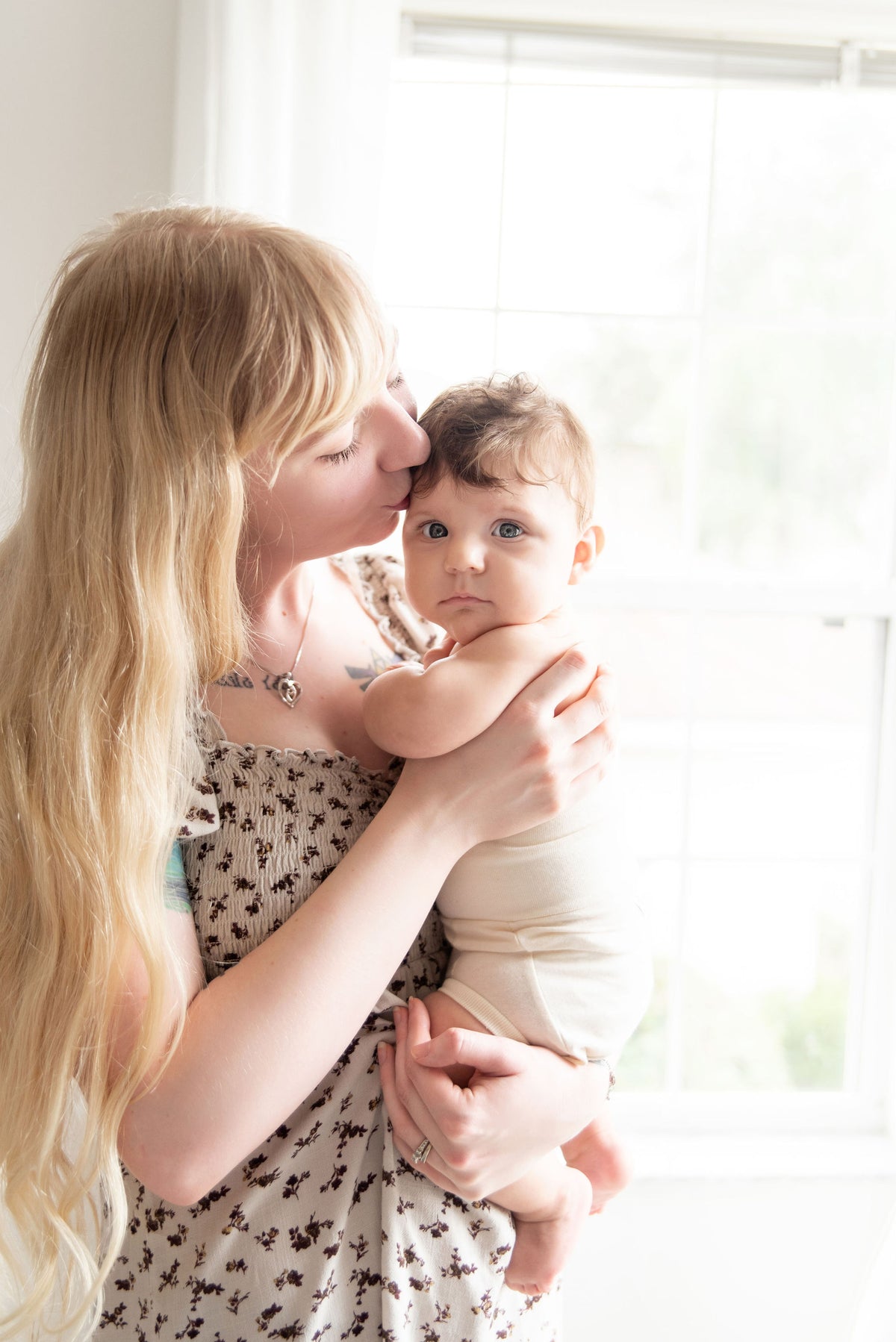 mom holding and kissing baby wearing naturelle unbleached cotton bloomer