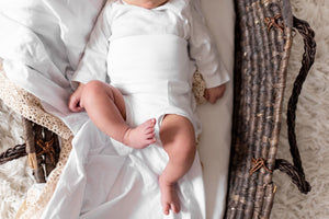 body shot of baby in basket in white organic cotton memeeno baby belly bloomer