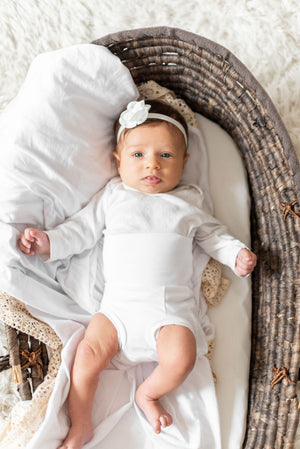 baby in basket wearing white organic cotton memeeno baby belly bloomer