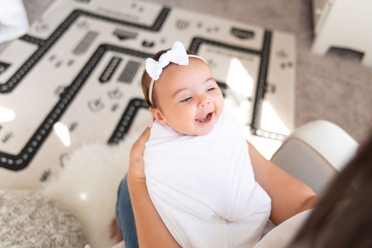 baby smiling while being held by mama