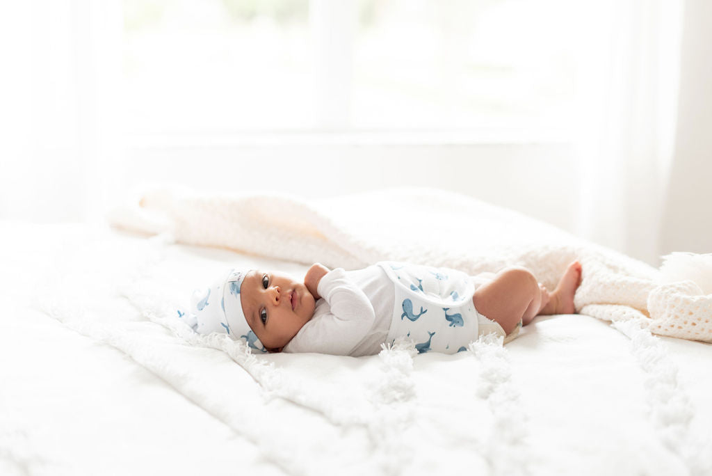 baby on bed wearing memeeno whale ceta organic cotton baby top knot hat