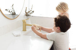 two kids at sink holding the sisal bag