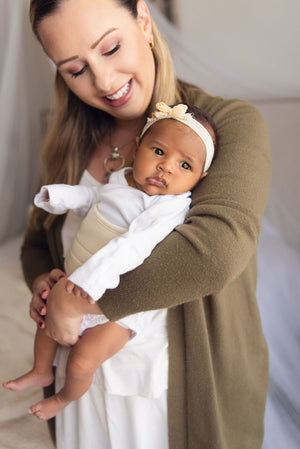 mom holding baby wearing baby wearing belly band sand