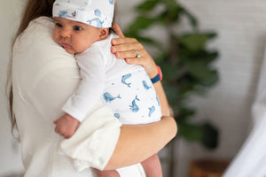 mom holding baby with ceta band and hat on