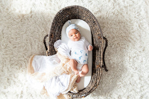 baby wearing ceta band and hat inside a basket