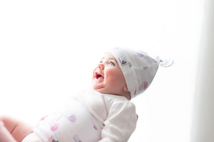 baby laughing while wearing aurelia belly band for colic relief and top knot hat jellyfish print