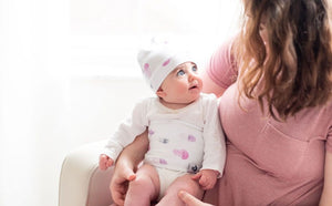 baby looking up at mom while wearing organic cotton belly band for colic relief and infant gas