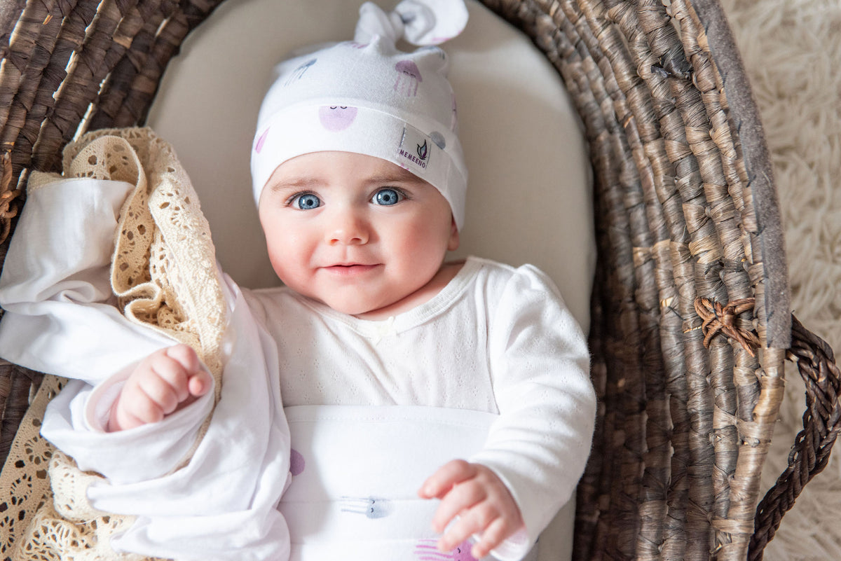 memeeno organic cotton belly band for colic relief and infant gas on baby in basket wearing the aurelia jellyfish print