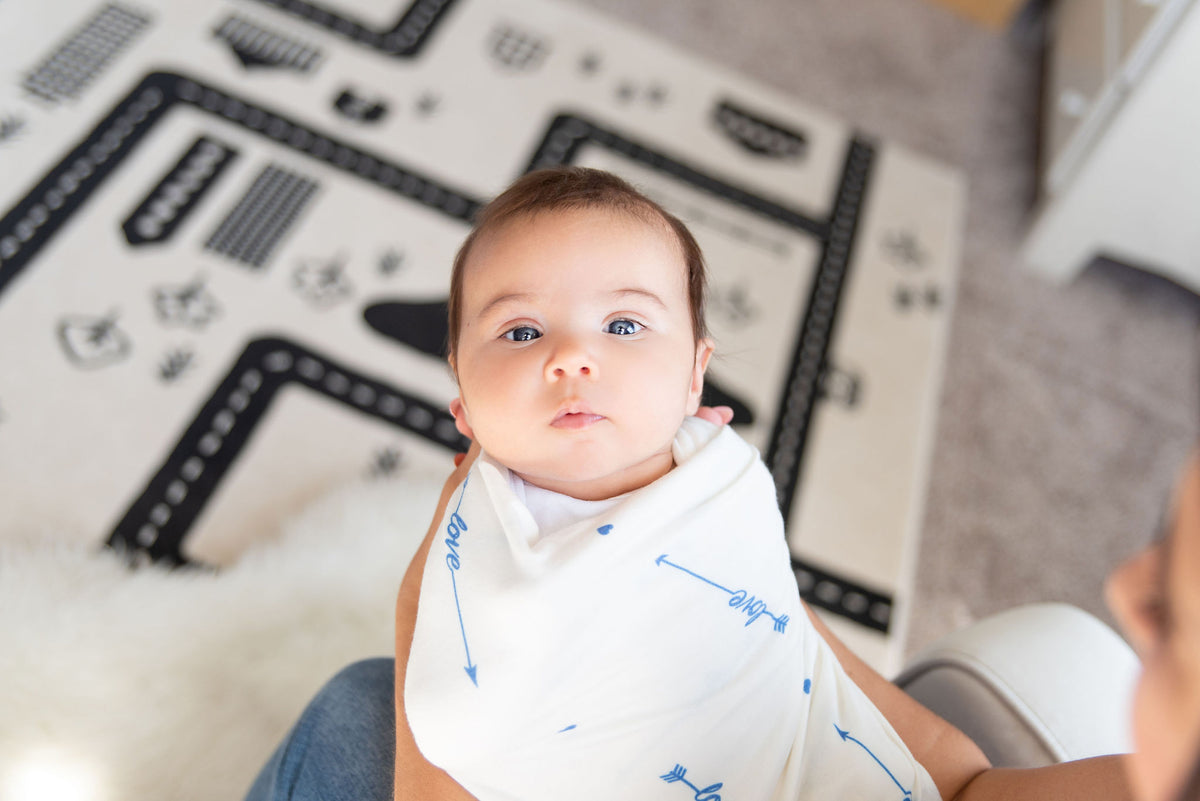mom holding baby in love him swaddle